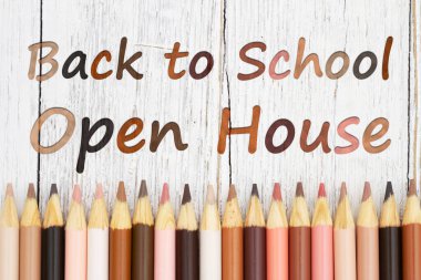 Back to school open house message with multiculture skin tone color pencils on weathered wood desk clipart