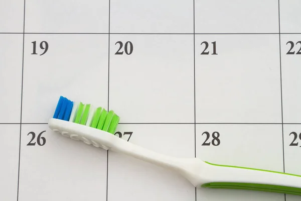 为清洁或检查而安排牙医预约的日历上的牙刷 — 图库照片