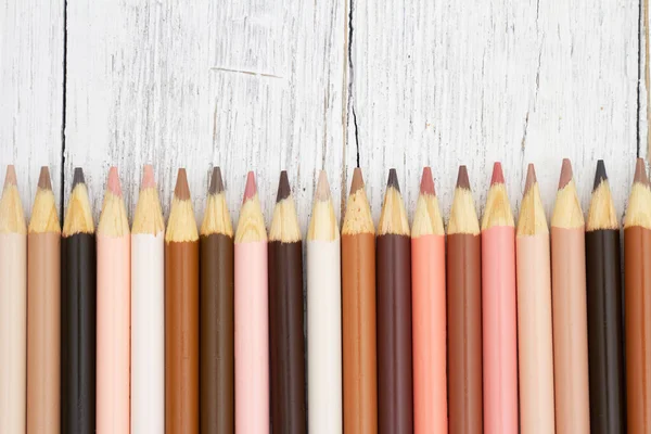 Multiculture skin tone color pencils background on weather wood for you education or school message