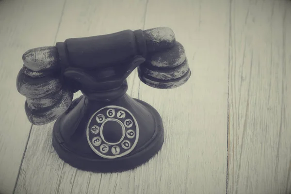 Vintage retro rotary dial phone on a weathered wood table