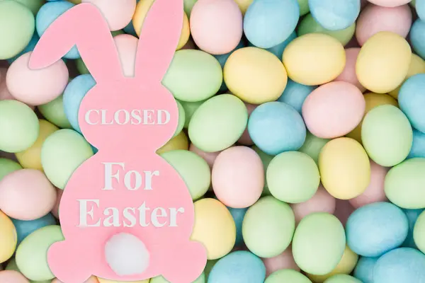关闭食客标志与粉红兔子和苍白复活节彩蛋糖果 — 图库照片