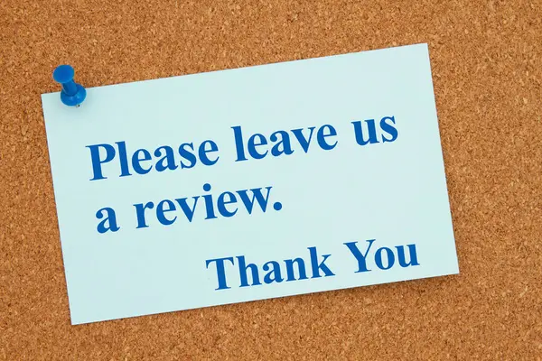 请给我们留一篇评论 谢谢你的蓝纸条和软木塞上的钉 图库照片