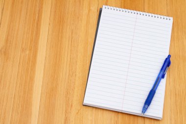 Okulda not almak için eski çizgili not defteri ve kalem yıpranmış masa 