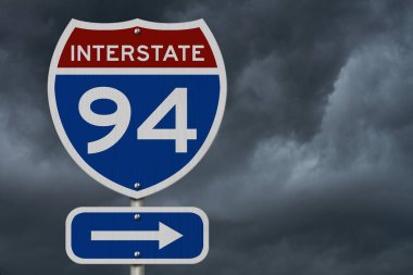 I-94 eyaletler arası kırmızı ve mavi yol işareti ve fırtınalı gökyüzü arka planı