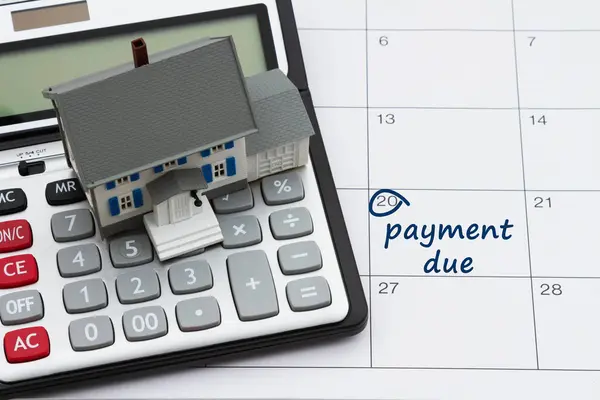 Hypotheek Betaling Verschuldigd Met Huis Zilver Rekenmachine Nota Een Kalender Rechtenvrije Stockfoto's