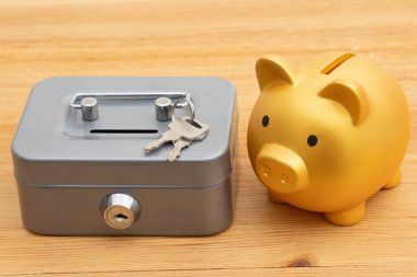 Paranı biriktirmek ve korumak için, kumbaranın kasasında, üzerinde anahtarlar olan bir ahşap masa.