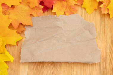 Mevsimlik mesajınız için yaprakları tahıllı tahtanın üzerinde boş bir kağıt parçasıyla bırakın.
