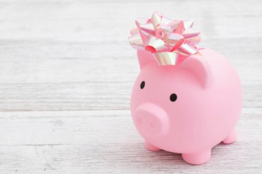 Pembe bir kumbara ve yıpranmış ahşap bir masa.