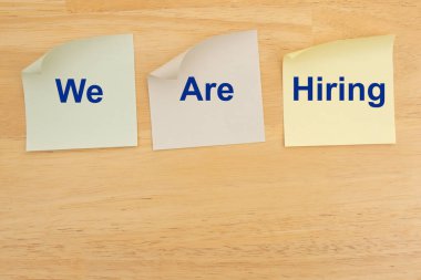 Ahşap masadaki yapışkan notlarda işe alım yapıyoruz. İş fırsatı ya da iş açılışı mesajı. 