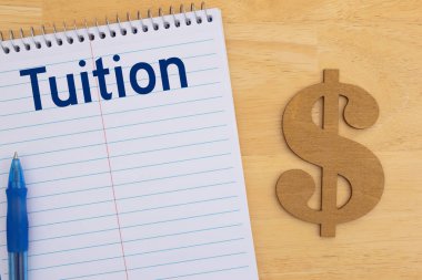 Okul harcı ve dolar işaretli bir defter. Bütçeyi ve eğitim giderleri için biriktirmeyi simgeliyor. Finans planlama kavramı.