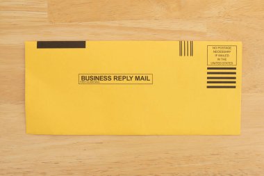 Posta pulları ve etiketleri postalanmaya hazır sarı zarf. İş mektupları ya da davetiyeler göndermek için mükemmel.