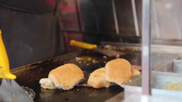 バーガーの準備 ストリートファーストフード シェフは外で薪焼きグリルでおいしいバーガーを準備しています バーベキューフェスティバル ハンバーグ肉焼き イタリアのブレシアでのサン ファウスティーノの饗宴 — ストック動画