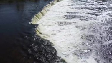 Venta Nehri 'nin şelalesinin üzerinde balıklarla uçuyor..