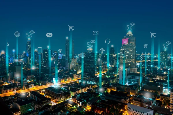 Modern technology of smart city concept, night cityscape, building light with internet services icon