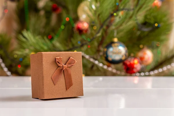 有弓的礼品盒圣诞树背景上闪烁着模糊的派对灯光和玩具球 圣诞节庆祝活动 — 图库照片