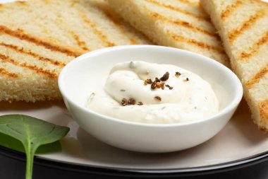 Peynir soslu beyaz porselen kase ve tabakta tost. Üst görünüm.