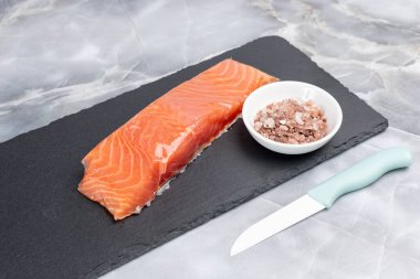 Kesme tahtasındaki tuzlu çiğ somon balığı filetosu. Üst görünüm.