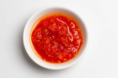 Ajika ya da Adjika. Domateslerden kırmızı sos, sarımsak ve biber. Beyaz arkaplanda üst görünüm. Ajika ya da Adjika. Domateslerden kırmızı sos, sarımsak ve biber. Beyaz arkaplanda üst görünüm.