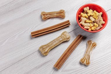 Köpekler için yiyecek. Bir kasede kurutulmuş hayvan maması. Granüle edilmiş hayvan yemi. Yapay köpek yerde vitaminlerle kemik yiyeceği çiğniyor. Köpekler için iyi beslenme.