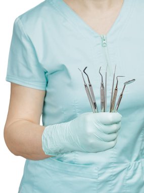 Dentist holding a set of composite filling instruments for dental treatment. Dental mirror, probe, plugger, tweezers and dental restoration instrument. clipart