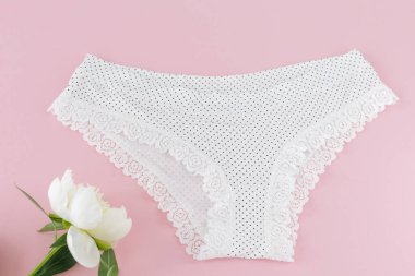 Pembe arka planda şakayık çiçekli bikinili pamuk külot. Kadın iç çamaşırı. Üst görünüm.