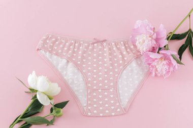 Pembe arka planda şakayık çiçekleri olan kısa bikinili pamuk külot. Kadın iç çamaşırı. Üst görünüm.