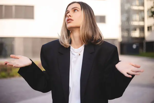 Hoşnutsuz genç iş kadını el sallayan esmer kadın çığlık atıyor. Bağırma, kavga konsepti. İş kadını sokakta ofis yakınında duran bir ceket giyer..