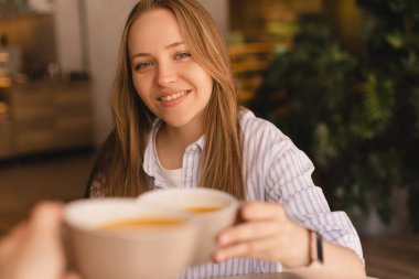 Kafede çay içerken gülümseyen ve konuşan beyaz kadınlar. Kızlar iyi sohbet eder, dedikodu yapar, güler. İletişim ve arkadaşlık kavramı - çay içen gülümseyen genç kadınlar. Şerefe.!