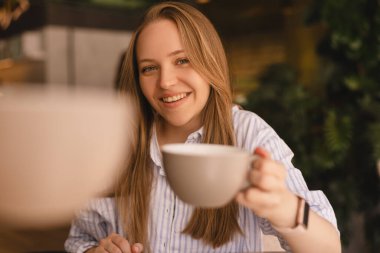 Kafede çay içerken gülümseyen ve konuşan beyaz kadınlar. Kızlar iyi sohbet eder, dedikodu yapar, güler. İletişim ve arkadaşlık kavramı - çay içen gülümseyen genç kadınlar. Şerefe.!
