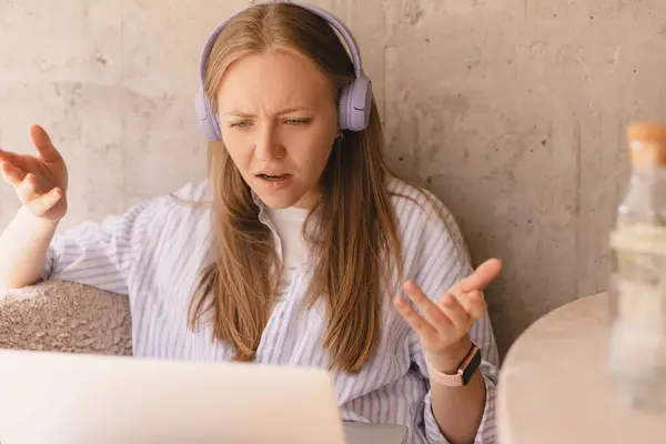 Stresli kızgın kadın, iş arkadaşlarıyla tartışıp kafeden çalışan dizüstü bilgisayarın önünde yeni projeyi tartışıyor. Kızgın kadın kulaklıkla ders çalışıyor..