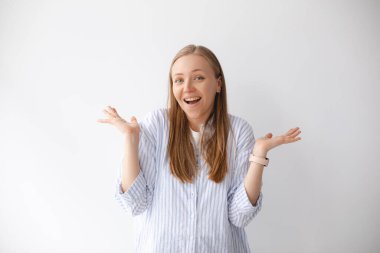 Şaşırmış ve mutlu, gülümseyen genç sarışın kız kazandığını fark etti, gerçekten iyi haberler aldı, yan yana uzandı ve kameraya hayret içinde baktı, beyaz arka planı şanslı ve neşeli..