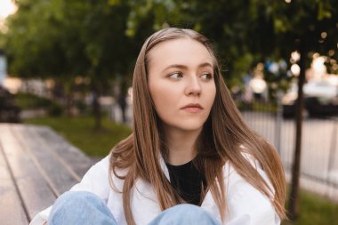 Gömlekli ve kotlu üzgün genç bayan bankta oturur, düşünür, baş ağrısı çeker ve parkta migren ağrısından muzdarip olur. Duygular, sağlık sorunları, stres ve baskı, hakaret, hücum kızı bacaklarına sarılıyor.