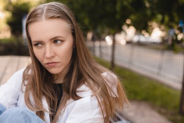 Gömlekli ve kotlu üzgün genç bayan bankta oturur, düşünür, baş ağrısı çeker ve parkta migren ağrısından muzdarip olur. Duygular, sağlık sorunları, stres ve baskı, hakaret, hücum kızı bacaklarına sarılıyor.