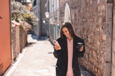 Güzel, gülümseyen bir kadın kahve siparişiyle sokakta yürüyor, cep telefonuyla sohbet ediyor. Akıllı telefondan konuşan kız buluşma yerine gidiyor, mesaj yolluyor, siyah takım elbise giyiyor..