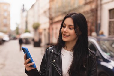 Genç, şık bir bayan öğrenci akıllı telefondan mesaj yazıyor. Eski şehir caddesinde yürüyor, hipster turistleri şehirde geziyor ve cep telefonu kullanarak seyahat planlıyor, kız sohbeti yapıyor, haberleri okuyor, mutlu görünüyor..