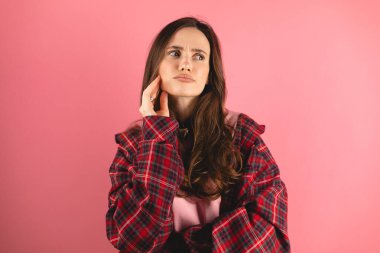 Aklı başında esmer bir kadının portresi. El ele, çene yana bak. Düşünce planı, ekose gömlek giy..