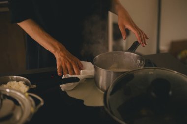 Pişirdikten sonra kirli elektrikli soba, süt biter, kadın ocağı kağıt havluyla yıkar, tencere tavayı sütle tutar. Mutfakta karışıklık..