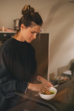 Kadınlar evde sütlü sütlü kahve pişiriyor. Yanında da kâse ve bambu ispirtosu. Mutfaktaki kasede yüksek ekmekli kibrit tozu olan mutlu kız..