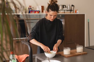 Kadınlar evde sütlü sütlü kahve pişiriyor. Yanında da kâse ve bambu ispirtosu. Mutfaktaki kasede yüksek ekmekli kibrit tozu olan mutlu kız..