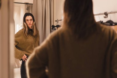 Modern genç bayanın, elbise mağazasında nasıl giyindiğini değerlendirme fırsatı var. Şık kıyafetler. Alışveriş ve zevk. Kızlar kazak giyer ve kot pantolon alır ya da giymez.