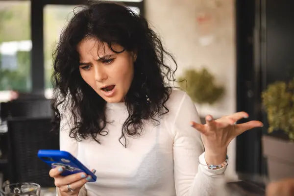 Güzel sinirli kıvırcık kadın kafenin büyük penceresinin yanında tek başına oturuyor, boş zamanlarında restoranda dinleniyor. Üzgün kızgın kadın cep telefonuyla kötü masaj okur, bağırır. Çığlık atan kadın.