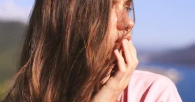 Kablosuz kulaklıklı çekici bir kadının portresi kameraya bakıyor ve gülümsüyor. Mutlu kadın dokunuşları kulaklıklar, dudaklar, flört eden bakışlar ve tatmin olmuş yüz ifadesi, müzik dinle..