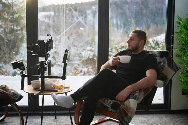 Videographer Man Resting Armchair Drinking Tea His Camera Mounted Gimbal — Stok fotoğraf
