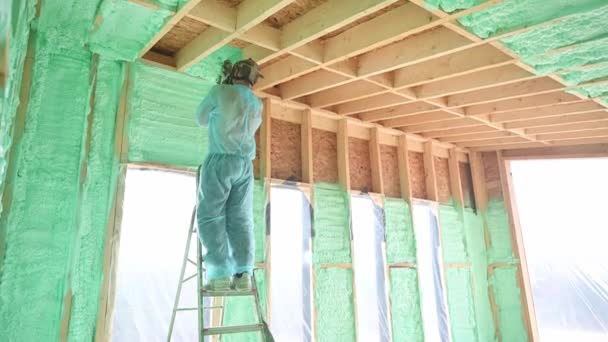 Male Builder Insulating Wooden Frame House Man Worker Spraying Polyurethane — Wideo stockowe