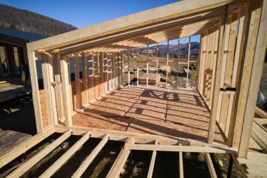 Aerial view of wooden frame house on pile foundation in the Scandinavian style barnhouse under construction in the mountains.