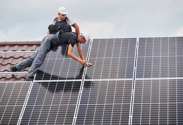 남자들 지붕에 모듈러 장착하고 기술자들은 지판을 야외에 설치하여 에너지와 에너지에 — 스톡 사진