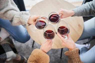 Genç kadınların el çırpışları ve kırmızı şarap içişleri. Çağdaş ahır evinde kış haftasonlarının keyfini çıkaran kızlar.