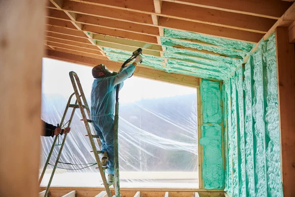Male Builder Insulating Wooden Frame House Man Worker Spraying Polyurethane — Zdjęcie stockowe