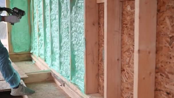 Male Builder Insulating Wooden Frame House Man Worker Spraying Polyurethane — Stock Video