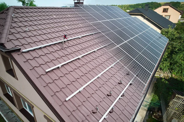 Photovoltaic solar panel fading away and shifting into metal supporting structure. Transition between metal rails and solar modules on roof of house. Concept of alternative energy sources. Aerial view